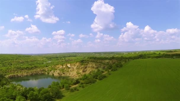 Laterala flygning över gröna fält med sjön. Antenn — Stockvideo