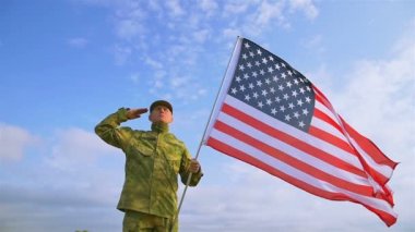 Asker selamı ile mavi gökyüzü karşı Amerikan bayrağı. Ağır çekim sahne