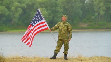 Amerikan bayrağı ile nehir kıyısında asker. Ağır çekim sahne
