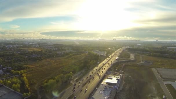 Snelweg met autoverkeer in avond zonlicht. Luchtfoto — Stockvideo