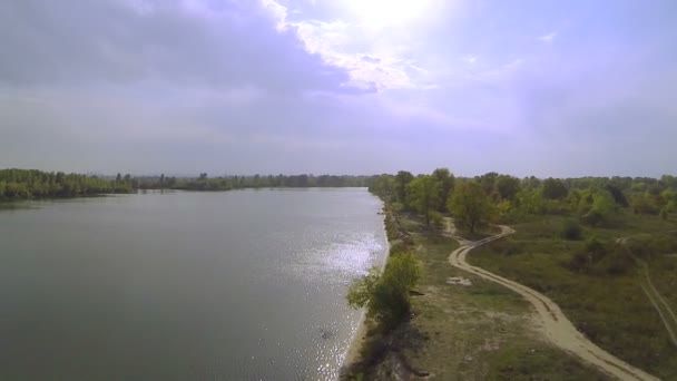 Vol en douceur au-dessus de la rivière avec reflets de soleil sur l'eau.Aérien 