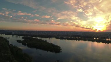 Nehir ve şehir üzerinde altın kırmızı günbatımı. Hava manzara panorama