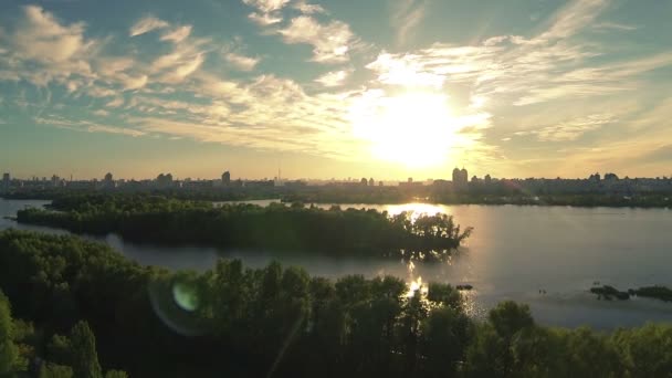 Güneş ışınları ağaç yaprakları ile akşam güzel nehir sahil üzerinde yukarı. Hava — Stok video