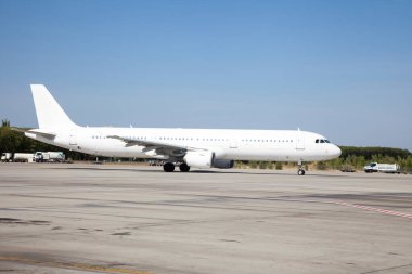 Havaalanı pistinde beyaz bir uçak kalkıyor. Kalkış ve iniş. Geliş ve gidiş. Mesaj için yer. Yolcu uçağı izole edilmiş. Uçak iniyor. Hava taşımacılığı ile seyahat et. Boşluğu kopyala.