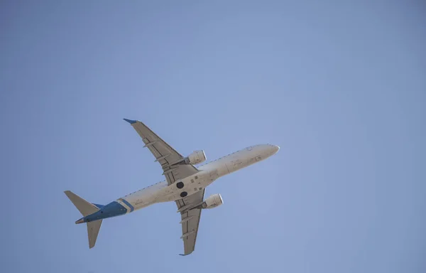 白い飛行機が空を飛ぶ 離陸と着陸だ 到着と出発 テキストの場所 青地に隔離された旅客機 — ストック写真