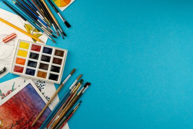 Suluboya boya ve fırça. Sanatçının çalışma yeri ve masası. Renk paleti. Arkaplan çizimi. Metnin için yer.