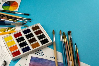 Suluboya boya ve fırça. Sanatçının çalışma yeri ve masası. Renk paleti. Arkaplan çizimi. Metnin için yer.