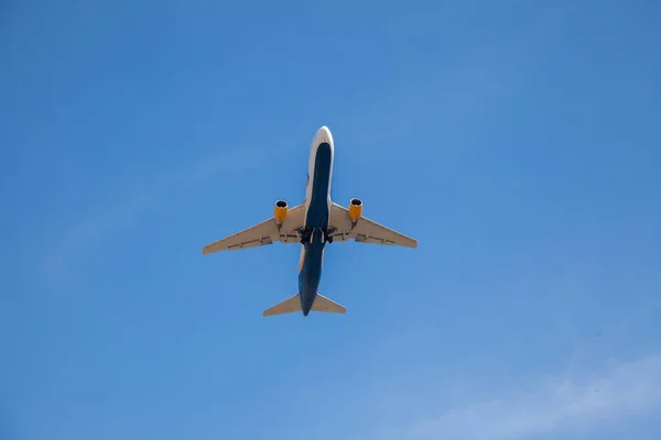 White plane flies in the sky. Bottom view. Takeoff and landing. Arrival and departure. Passenger plane isolated on blue background. Airplane flying. Travel by air transport. Copy space. — Stock Photo, Image