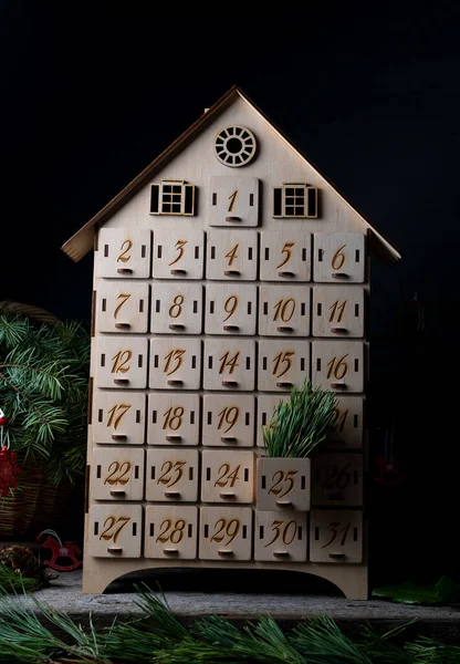 Yeni yılı ya da Noel 'i beklemek için ahşap takvim. Hücre sayısı 1 'den 25' e ve 31 'e kadar olan kutular mini hediyeler için. Aralık atmosferi ve dekor