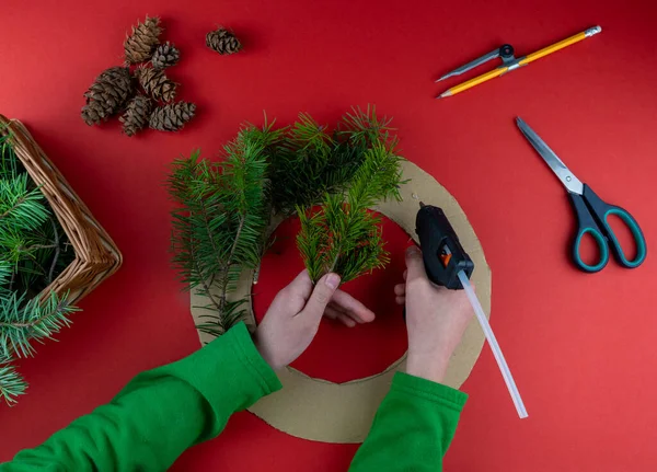 第三步一步一步的指示 如何用针叶树树枝 纸板和胶水枪制作圣诞花环 新年的装饰 创意工艺 你自己来吧Diy — 图库照片