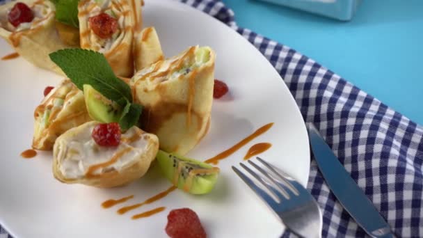 果物の充填とパンケーキはロールにロール 白いプレートの上にオスマナとフルーツの薄いパンケーキ パンケーキの日のためのお祭りの食べ物 ストロベリージャムのパンケーキ バター皿 — ストック動画