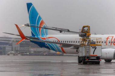 Ukrayna, Kyiv - 29 Aralık 2020: havaalanında Deice. Flydubai yolcu uçakları kalkıştan önce antifriz ile tedavi edilir. Kışın havaalanı. Uçuş servisi. Meyve suyu makinesi. Siste uçak..