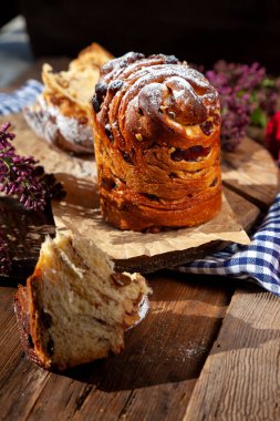 Paskalya pastası keki. Kuru üzümlü Kraffinler, şekerli meyveler ve haşhaş tohumları, üzerine toz şeker serpiştirilmiş. Ev yapımı pastaya yakın çekim. Cüce. Kırmızı renkli yumurtalar..