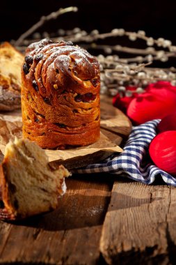 Paskalya pastası keki. Kuru üzümlü Kraffinler, şekerli meyveler ve haşhaş tohumları, üzerine toz şeker serpiştirilmiş. Ev yapımı pastaya yakın çekim. Cüce. Kırmızı renkli yumurtalar..