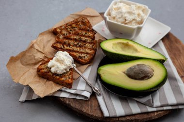 Yumuşak peynirli sandviç, avokado ve salatalık. Kahvaltınız masada. Sağlıklı yiyecekler. Kadeh kaldıralım ve üzerine yayalım. Avokado sandviçi ölü yaşam. Sağlıklı yemek..