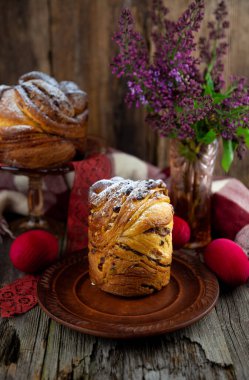 Paskalya pastası keki. Kuru üzümlü Kraffinler, şekerli meyveler ve haşhaş tohumları, üzerine toz şeker serpiştirilmiş. Ev yapımı pastaya yakın çekim. Cruffin..
