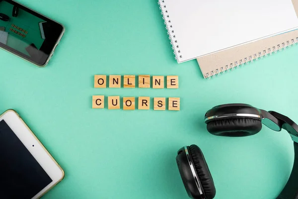 Online course. The phrase is laid out in wooden letters. View from above. Motivation. Copy space.Tablet, Headphones stationery. distance learning. Table Flatlay.