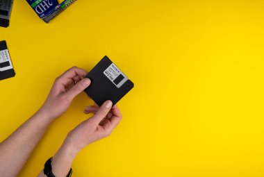Ukrayna, Kyiv - 7 Şubat 2021: SONY Disket 3.5 inç. Disketler 32, 80 'lerin teknolojisi. Retro, klasik ve renkli bilgisayar disketi. Sarı arka plan. Eller yukarı. Boşluğu kopyala.