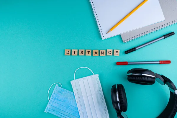 Distance. The phrase is laid out in wooden letters. View from above. Motivation. Copy space. Tablet, Headphones stationery. distance learning. Table Flatlay. Online work, study, education.