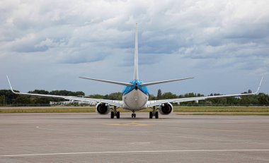 Yolcu uçağı iniyor. Havaalanı platformunda mavi bir uçak. Pist. İniş uçağı.