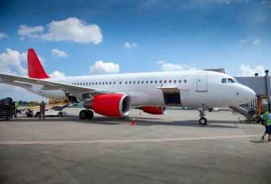 Bagajı bagaj bölümüne yüklüyorum. Uçak havaalanı platformunda. Mavi gökyüzü. Seyahat et. Havadan uçuşlar. Pist. Yakın çekim, kopyalama alanı. Yolcu uçağı.