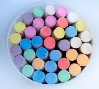 Büyük bir kova dolusu çok renkli tebeşir. Açık hava boyama seti. Çocuk eğlencesi ve hobisi. Yakın çekim, üst görünüm.