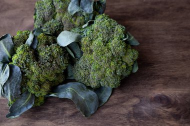 Tahta arka planda brokoli. Lahana, yeşil sağlıklı sebze. Yeşil yapraklar.