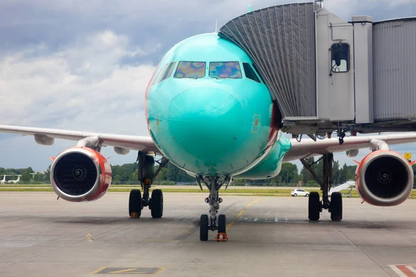 Passenger plane at the airport. Boarding passengers through the boarding bridge. Loading and unloading of baggage. Passenger aircraft on the runway. Plane landing. Copy space.