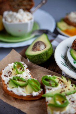 Yumuşak peynirli sandviç, avokado ve salatalık. Kahvaltınız masada. Sağlıklı yiyecekler. Kadeh kaldıralım ve üzerine yayalım. Avokado sandviçi ölü yaşam. Sağlıklı yemek..