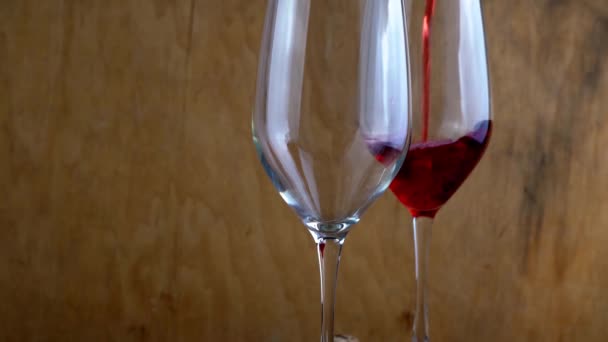 Zwei Gläser Rotwein. Alkoholisches Getränk im Glas. Eine Flasche Wein. Hölzerner Hintergrund. — Stockvideo