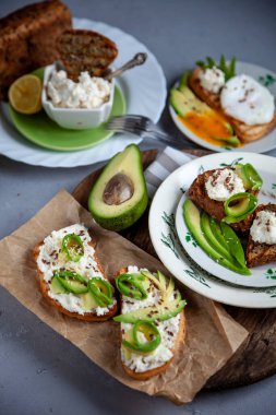 Yumuşak peynirli sandviç, avokado ve salatalık. Kahvaltınız masada. Sağlıklı yiyecekler. Kadeh kaldıralım ve üzerine yayalım. Avokado sandviçi ölü yaşam. Sağlıklı yemek..