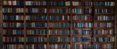 Kütüphanede kitaplıklar var. İçinde bir sürü eski kitap olan büyük bir kitaplık. Kitap okuyorum. Kütüphane ya da kitaplıklı bir dükkan. Samimi kitap arkaplanı.