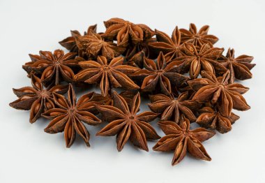 Beyaz arka planda izole edilmiş anason yıldızları. Kokulu baharat, baharat. Badian kurutulmuş meyveleri. Anason yıldızı yakın plan.