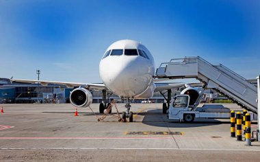 Uçağa binen yolcular. Kalkış köprüsü. Önlükteki uçak. Uçak boş uluslararası havaalanına iniyor. Bagajları yüklüyorum. Beyaz uçak. Terminal Pist. Boşluğu kopyala.