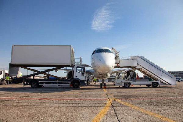 Handling and catering service. Boarding passengers on the plane. Boarding bridge. Aircraft. The plane lands at the empty airport. Loading luggage. White airplane. Terminal Runway. Copy space.