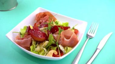 Armut salatası, haşlanmış armut, dor mavi peynir ve prosciutto. Marullu jamon eti, salatalık. Cevizli sağlıklı bir öğle yemeği. Beyaz tabakta yemek. Et yemeği. Kasede salata. Susam.