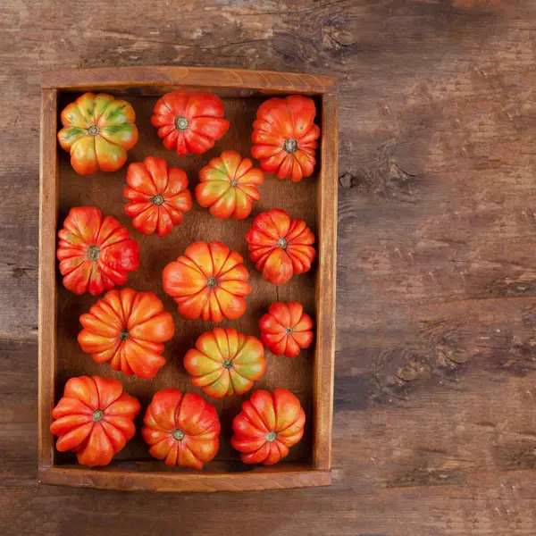 Żebrowane pomidory w drewnianej tacy widok z góry. Odbiór. Pomidor letni — Zdjęcie stockowe