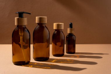 Kozmetik için çevre dostu şişeler. Cam şişe, tahta kapaklı, şeker kutusu ve pipetli. Güzellik ve cilt bakımı. Marka ambalajı, mesaj için yer. Vücut ürünleri için bir şişe. Minimalizm kavramı.