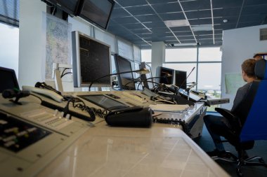 Hava trafik kontrol işyeri. Kuledeki havaalanında havalanan ve inen uçaklardan sorumlu müdürün çalışma alanı. Monitörler, sandalyeler, bilgisayarlar. Hava kontrol merkezi ofisi. Eşsiz iş.