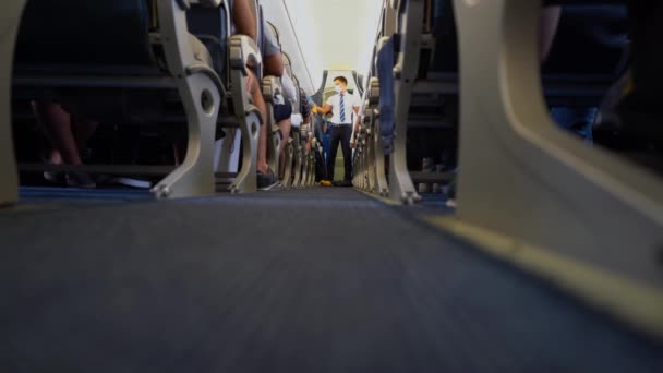 Ukraine, Odessa - 3 août 2021 : Un steward dans l'avion montre comment mettre un masque à oxygène. L'agent de bord dans l'allée entre les sièges démontre la sécurité des vols. UIA compagnies aériennes internationales. — Video