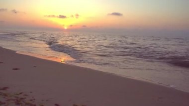 Denizde gün batımı. Akşam güneşi ve patika. Güzel gökyüzü ve bulutlar. Sahildeki manzara. Okyanus kıyısında. Şafak Doğa. Dalgalar ve sörf. Rahatlama ve sakinlik. Deniz Burnu. Kumsalda dalgalı su