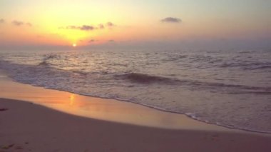Denizde gün batımı. Akşam güneşi ve patika. Güzel gökyüzü ve bulutlar. Sahildeki manzara. Okyanus kıyısında. Şafak Doğa. Dalgalar ve sörf. Rahatlama ve sakinlik. Deniz Burnu. Kumsalda dalgalı su