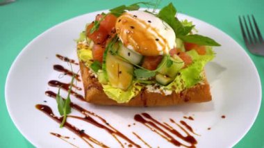 Somonlu tost ve haşlanmış yumurta. Marul, salatalık, fesleğen. Sağlıklı bir kahvaltılık sandviç. Mikroyeşil, keten ve susam tohumları. Beyaz tabakta sağlıklı yemek. Sebzeli balık.