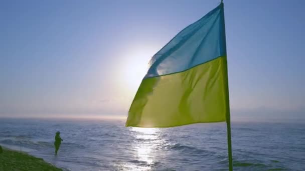 Україна, Одеса - 3 серпня 2021: під вітром пролітає український прапор. Море і сонце. Морське узбережжя. День відпустки та незалежності. Україна. Природа і мореплавство. Переїзд і відпочинок — стокове відео