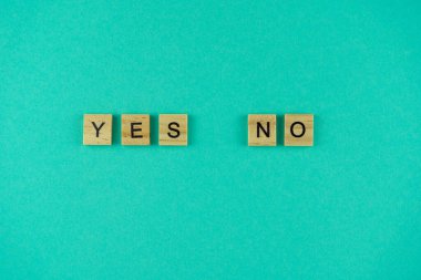 Kelime evet ve hayır. Sözcük ahşap harflerle yazılmıştır. Üst Manzara. Motivasyon. Mavi arka plan. Boşluğu kopyala.