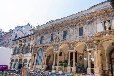 İtalya, Milano - 17 Temmuz 2025: Piazza Mercanti, Milano 'nun orta kesimindeki eski sokak evleri mimarisinin merkezi kent meydanı. İtalyan binası. Pencere duvarı kemer cephesi.