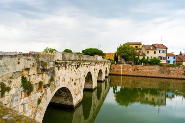 Rimini 'deki nehrin üzerindeki Tiberius Köprüsü. İtalyan klasik mimarisi. Şehir simgesi. İtalya eski evleri