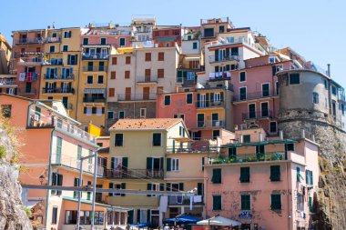 Turist rotası. Uçurumdaki parlak renkli evler. Manarola İtalyan köyü Liguria denizi. Cinque Terre mimarisi. İtalya, Manarola - 15 Temmuz 2025.