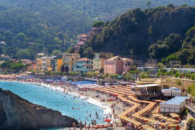 Yazın sahilde şemsiyeler. Ligurian Denizi kıyısında İtalyan tatili. Liguria Cinque Terre rock. İtalya, Monterosso - 15 Temmuz 2025.