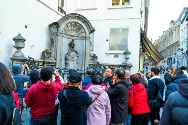Brüksel, Belçika - 28 Ekim 2025: İşeyen çocuk Manneken Pi. Brüksel Caddesi Belçika 'daki turizm yüzünden. Birçok turist fotoğraf çeker.